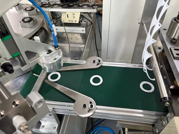 Automatic felt die cutting machine with robotic arms and conveyor belt for high-efficiency manufacturing.jpg